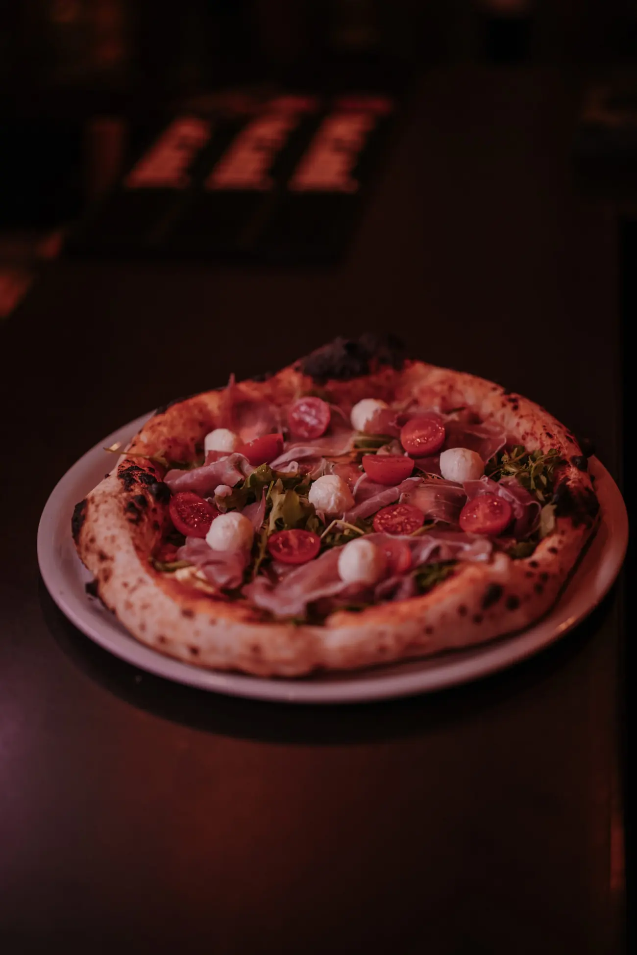 Neapolitanische Pizza mit Parmaschinken und Datteltomaten