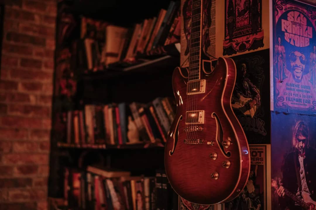 Gitarre an der Wand neben den Büchern